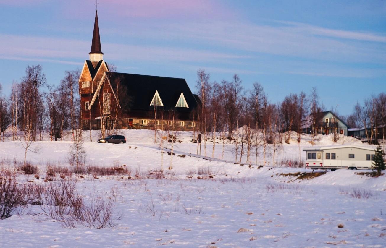 Remote Arctic church surrounded by deep snow during the polar night in Lapland