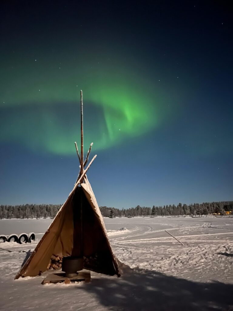 Northern lights in the back of this iglu during the polar night in FInland