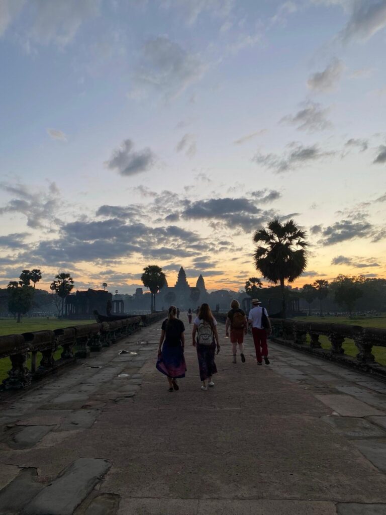 Tourist standing on top of Angkor Wat tower overlooking the temple grounds